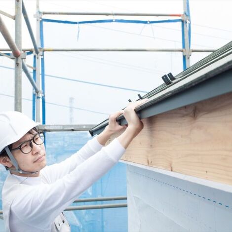 屋根の作業をする建築現場の男性スタッフ