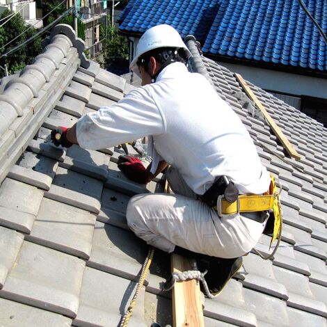 屋根を補修する職人